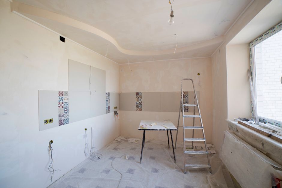 Kitchen under renovation with a ladder and tools on the floor.